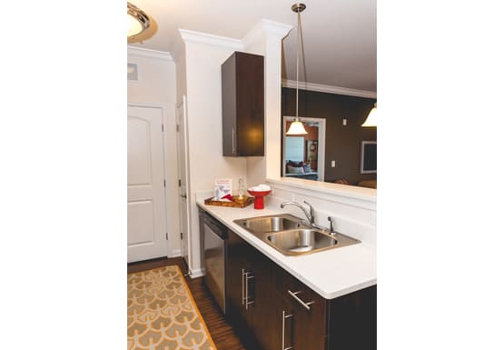Kitchen with dark cabinets; open to living room