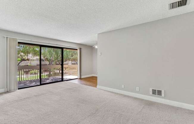 an empty living room with sliding glass doors to a balcony at Summerwood Apartments, Santa Clara, CA 95050