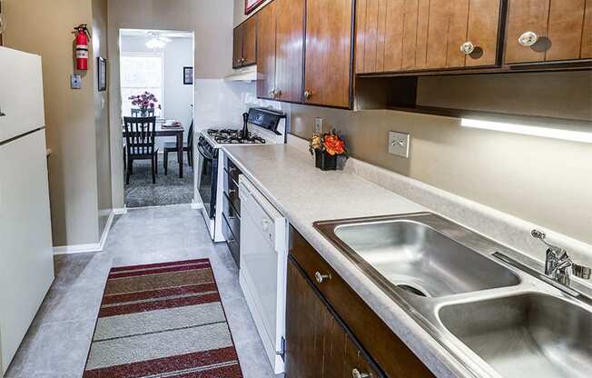 Fully equipped kitchen at Ashton Pointe Apartments with white appliances and cabinets