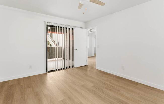 A room with a wooden floor and a ceiling fan.