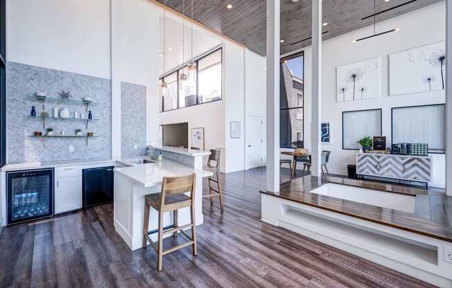 A kitchen with a white counter top and wooden floors.