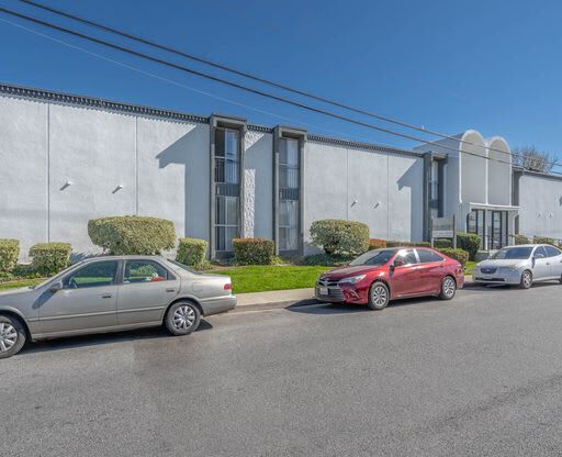 a building with cars parked in front of it at The Arches Apartments, California