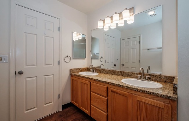 a bathroom with two sinks and a white door