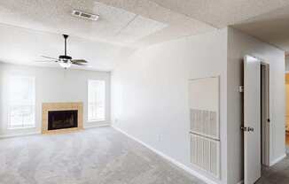 A room with a fireplace and a ceiling fan.