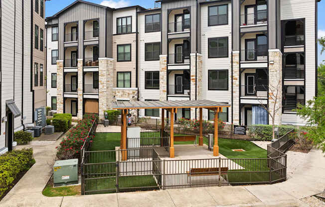 A modern apartment complex with a courtyard and a gazebo.