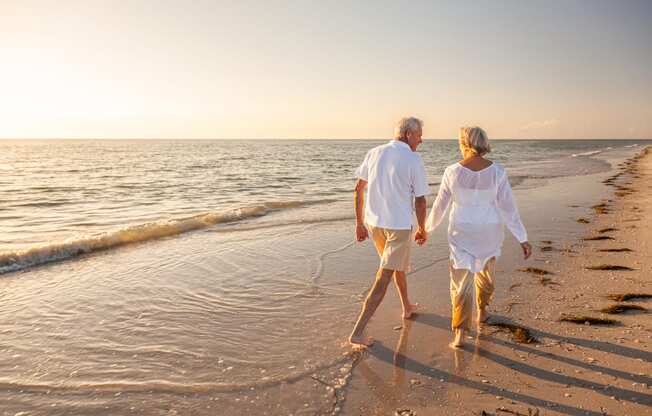 a man and a woman walking on the beach