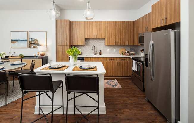 a kitchen with stainless steel appliances and a table with chairs