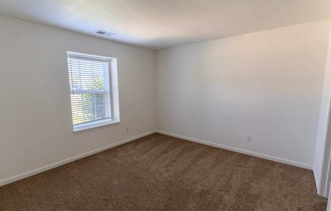 an empty room with carpet and a window