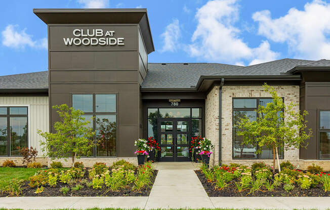 The front of the Club at Woodside building with a clear blue sky in the background.