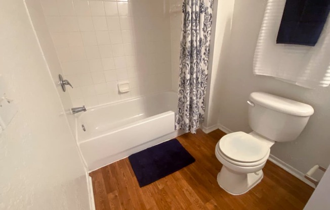 Bathroom with hardwood style flooring and tiled shower