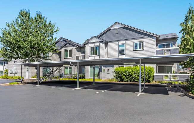 A large grey apartment building with carports in front at The Landing Apartments and Townhomes, Oregon, 97045