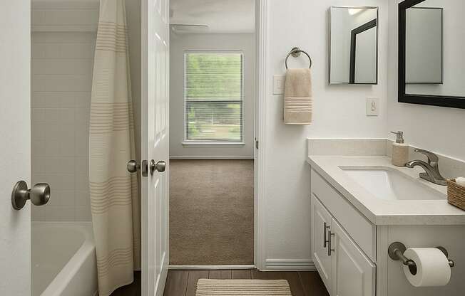 A bathroom with a white sink and a white towel hanging on the wall.