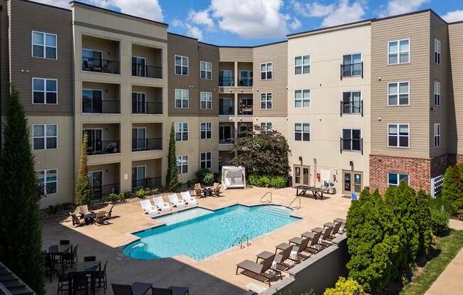 A large apartment complex with a pool in the courtyard.