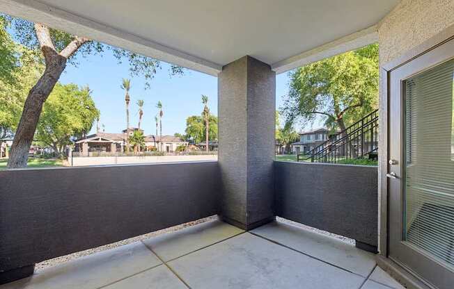 A patio with a view of a tree and houses.