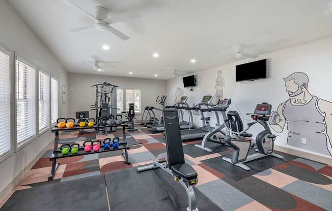 a home gym with exercise equipment and a wall mural of a man on the wall at Paisley and Pointe Apartments, Las Vegas, NV