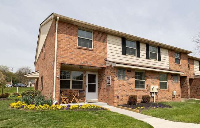A brick house with a white door and windows.