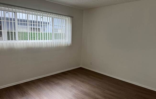 Bedroom with wood flooring and window