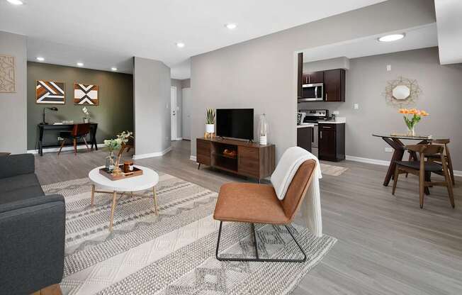 A living room with a grey couch, a brown chair, and a white coffee table.