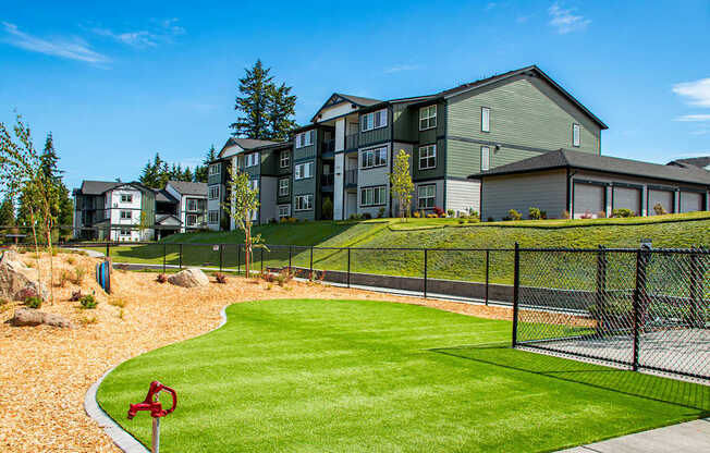 A red flag marks the corner of a well-kept lawn in front of apartment buildings.