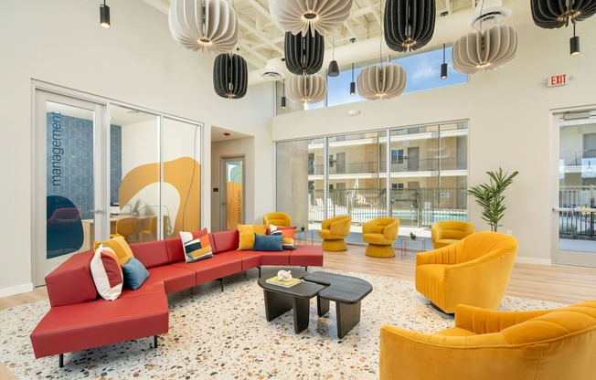 A brightly colored waiting area with a red couch and yellow chairs.