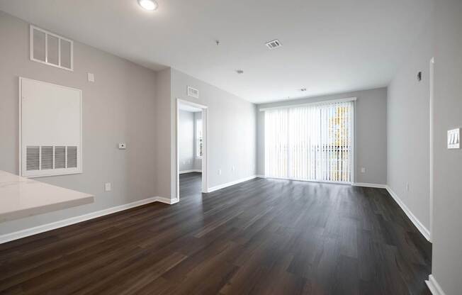 A large empty room with wooden floors and white walls.