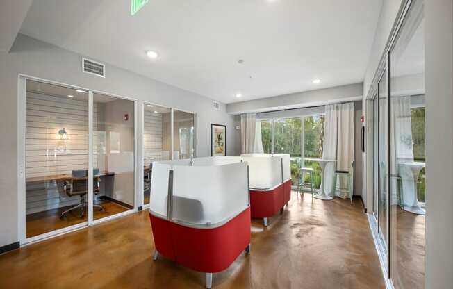 a living room with red and white furniture and glass doors