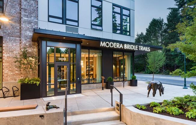The welcoming leasing office showcases contemporary architecture, expansive windows, and thoughtfully designed landscaping that reflects the community's modern Pacific Northwest aesthetic.