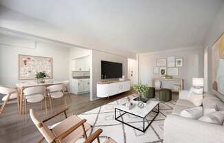 A modern living room with a white sofa, wooden chairs, and a coffee table.