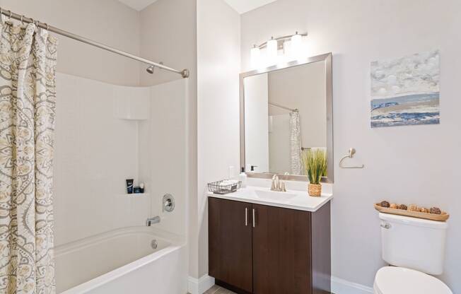 a bathroom with a shower sink and toilet and a mirror at The Tannery, Connecticut, 06033