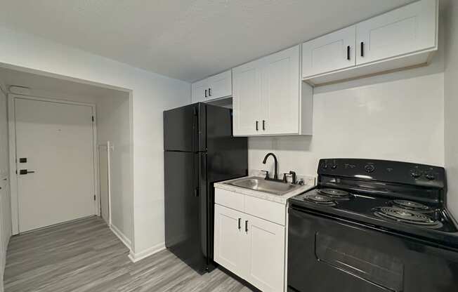 a kitchen with white cabinetry and black appliances