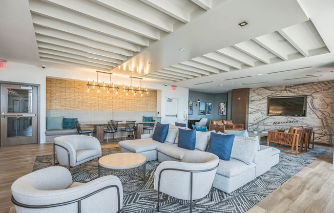 A spacious living room with a stone fireplace and a variety of seating options.