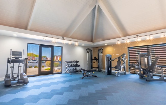 a gym with weights and cardio equipment and a glass door