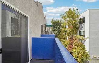 A blue wall with a black door and a window.