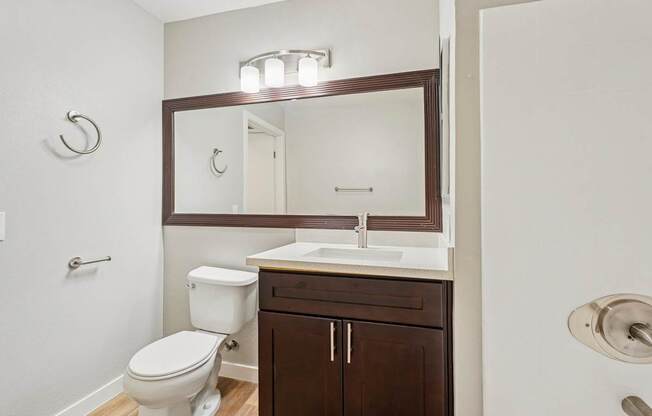 A white toilet sits next to a sink in a small bathroom.