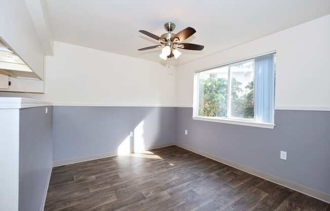 an empty room with a ceiling fan and a window