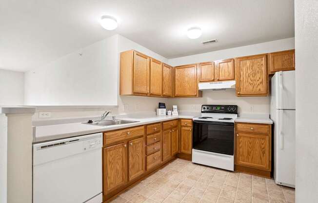 A kitchen with wooden cabinets and white appliances.