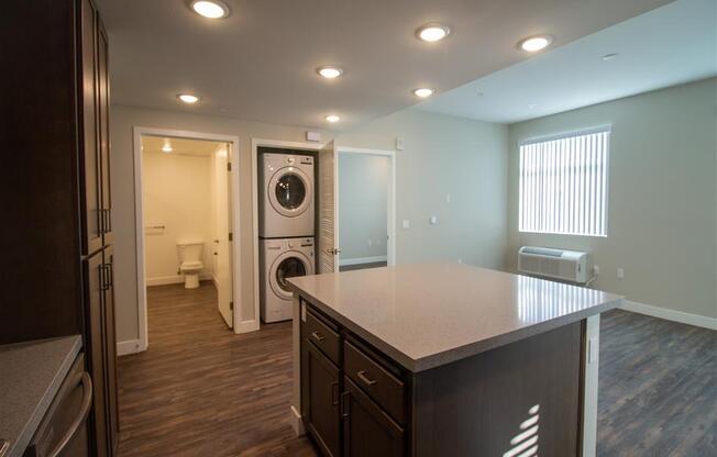 a kitchen with an island and a washer and dryer at Loma Villas Apartments, San Bernardino, CA