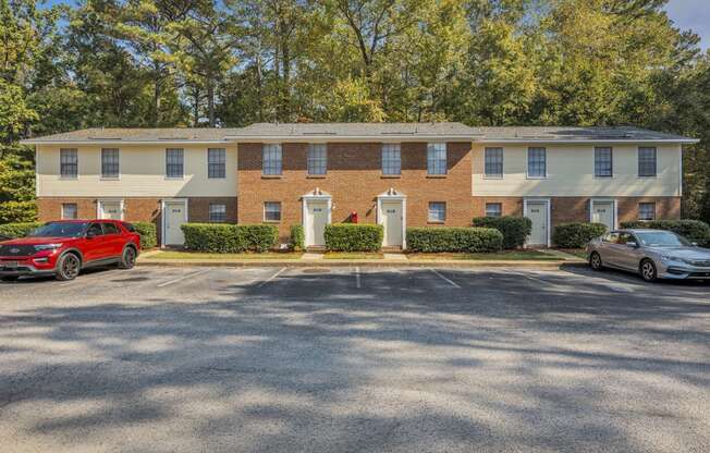 a brick apartment building with cars parked in front of it