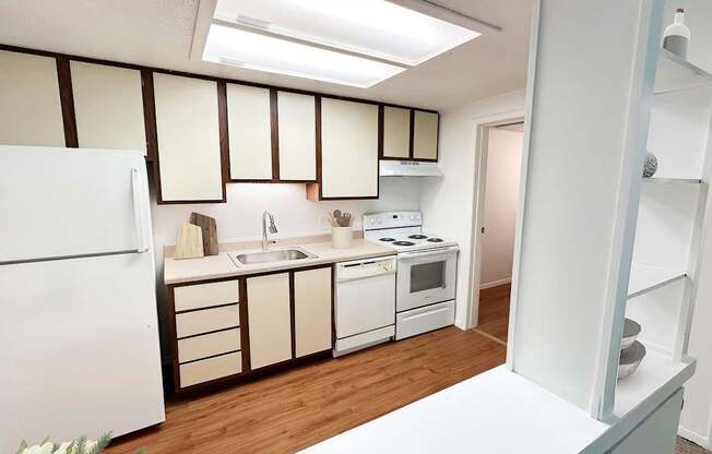 A kitchen with white appliances and wooden floors.