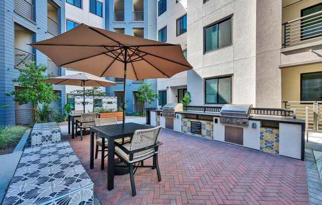 A patio with a table and chairs and an umbrella.