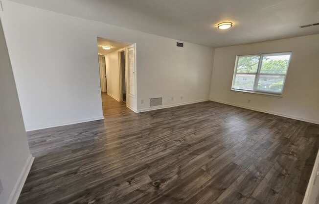 the living room of an empty house with wood flooring