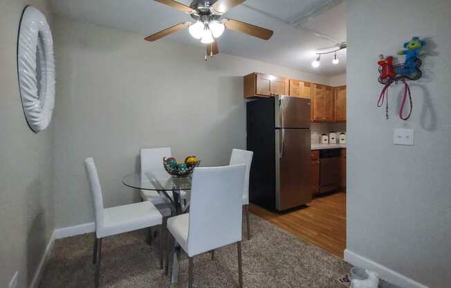 a dining room with a table and chairs and a kitchen with a refrigerator