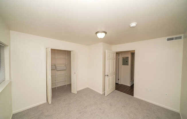 an empty bedroom with a walk-in closet