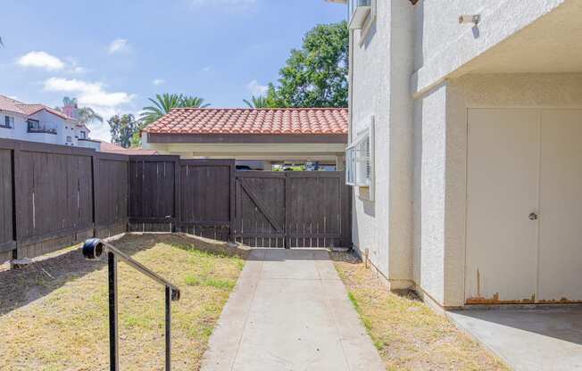 the entrance to a fenced in yard of a house