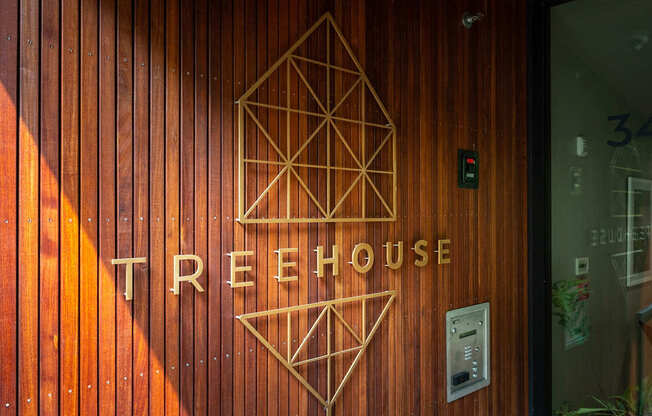 the facade of the treehouse is lit up at night with three geometric shapes on