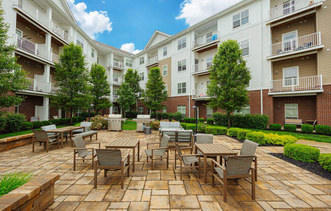 an outdoor patio with tables and chairs at an apartment complex