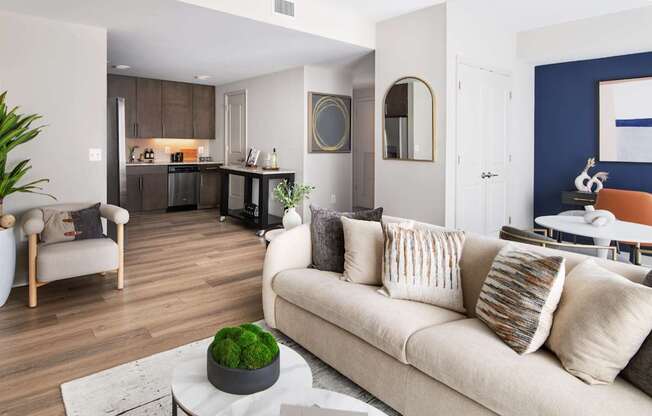 A living room with a couch, a coffee table, and a potted plant.