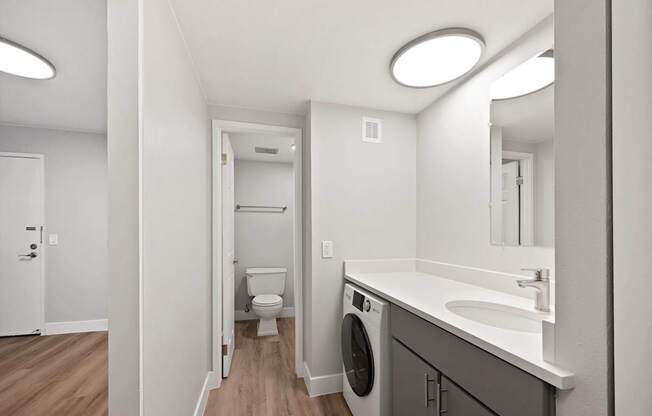 A bathroom with a washer and dryer built into the cabinetry.