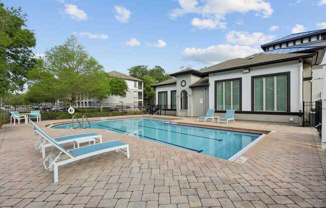 A pool with a blue tiled edge and a white sunbed.