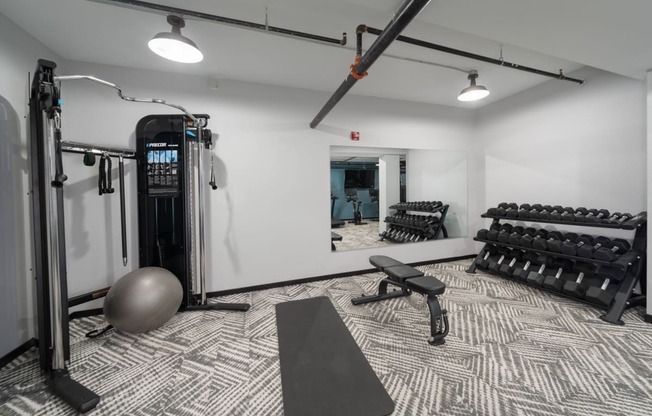 a spacious fitness room with cardio machines and weights